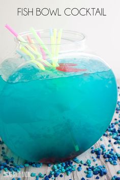 a fish bowl cocktail with blue liquid and straws in it