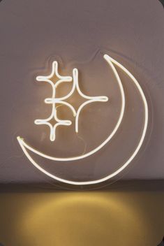 a neon sign that is hanging on the wall next to a light up moon and stars