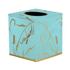 a blue tissue box with gold leaf designs on it and a black liner in the middle