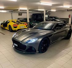 two sports cars parked in a garage next to each other