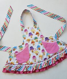 a child's apron made out of fabric with cupcakes on the front