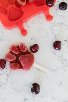 cherries and ice cream on a marble counter top with a heart shaped molder