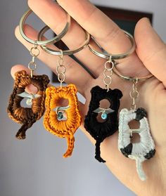 three crocheted keychains are being held in the palm of someone's hand