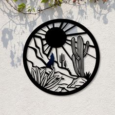 a circular metal wall hanging with a bird and cactus