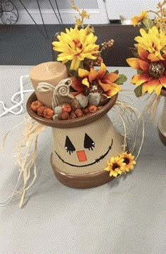 two ceramic pots with sunflowers and other decorations