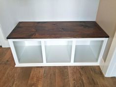 a wooden shelf with glass doors on the top and bottom, in a room that has wood flooring