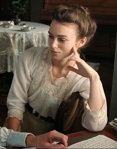 a woman sitting at a table in front of a computer