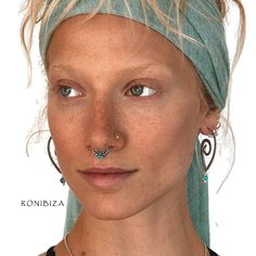 a woman with piercings on her nose and wearing a head wrap around her neck