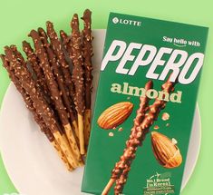 a box of peppero almonds next to some pretzels on a plate