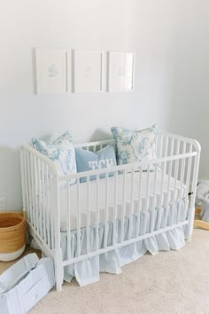 a white crib with blue and white pillows