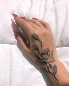 a woman's hand with a rose tattoo on it