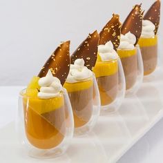 small desserts are lined up on a white tray