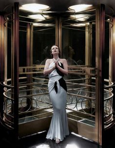 a woman standing in front of a glass elevator