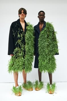 two people standing next to each other covered in grass