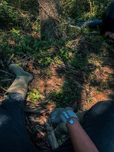 two people sitting in the woods with their feet up