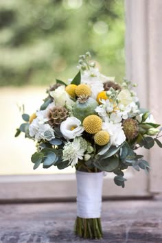 a bouquet of flowers sitting on top of a table next to a window sill