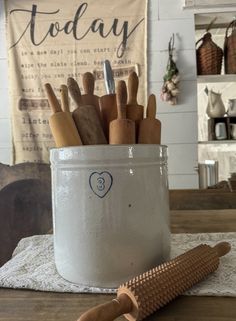 a white container filled with wooden utensils on top of a table