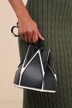 Elevate your accessories game instantly with the Lulus Unparalleled Style Black and White Color Block Bucket Bag! Smooth vegan leather, in contrasting hues of black and white in a geometric-style design, shapes this structured bucket bag with a flat bottom silhouette and a unique drawstring top that cinches with slender, twin tote handles. A slender, detachable shoulder strap allows for various styling options, while the roomy interior keeps all your must-have essentials safe and sound! Gold har Black Structured Bag With Removable Pouch, Modern Black Geometric Bags, Black Geometric Bag For Everyday Use, Modern Geometric Bag With Adjustable Strap, Trendy Black Geometric Bag, White Geometric Bag For Everyday Use, Black Structured Bag With Adjustable Strap, Modern Black Bag With Magnetic Closure, Structured Black Bag With Adjustable Strap