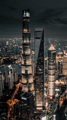 an aerial view of a city at night with skyscrapers lit up in the background