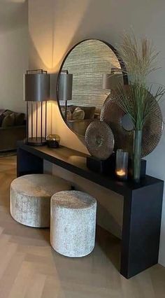 a living room filled with furniture and a round mirror on top of a wooden table