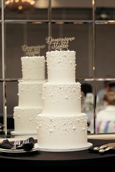 three tiered white wedding cake sitting on top of a table