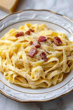 a white plate topped with pasta and bacon