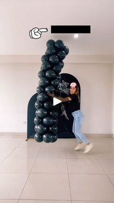 a woman standing in front of a giant balloon arch with the words she made on it