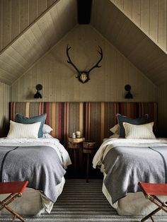 two beds in a room with striped headboards and pillows on top of each bed