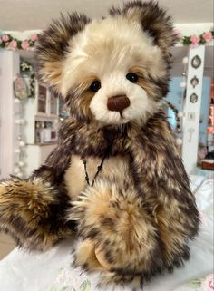 a stuffed teddy bear sitting on top of a bed