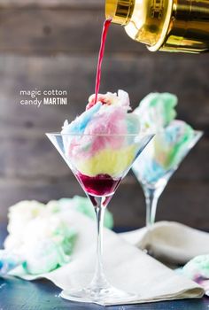 someone pouring wine into a glass filled with ice cream and colorful swirly toppings