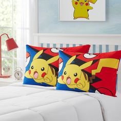 two pillows with pokemon characters on them sitting on a bed