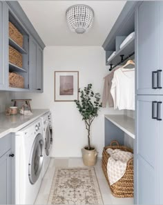 a washer and dryer in a laundry room with blue cabinets, white walls and drawers