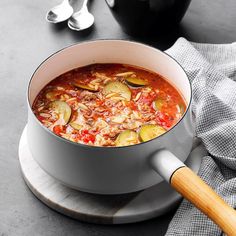 a white pot filled with soup on top of a table