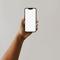 a person holding up a cell phone with a white screen in their hand, against a gray background