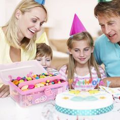 a man and two girls looking at a birthday cake