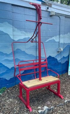 a red chair sitting in front of a blue wall