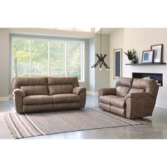 a living room with two recliners and a rug in front of the window