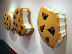 three yellow and white decorative objects on the wall