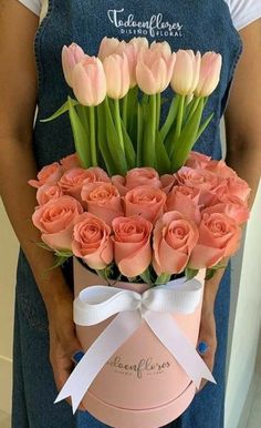 a person holding a pink box with flowers in it