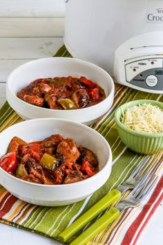 two white bowls filled with food next to an electric crockpot on a table