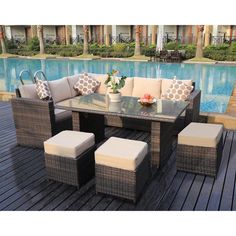 an outdoor table with four chairs next to a pool