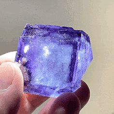 a person holding up a purple stone in their hand