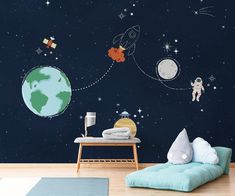 the space wall mural is painted in blue and features an astronaut's rocket ship, planets