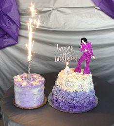 two purple and white cakes with sparklers in the middle, one is for a birthday