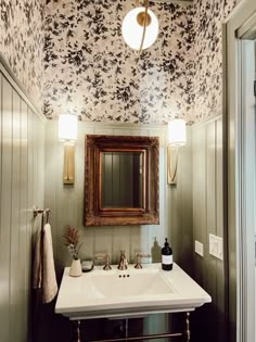 a bathroom sink under a mirror next to a wall mounted faucet and light