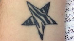 a black and white star tattoo on the arm