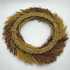 a wreath made out of dried grass on a white background