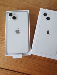 two new iphones in their boxes on a table