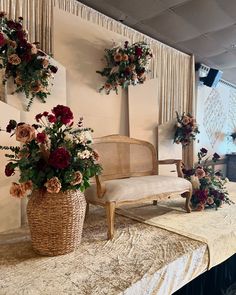 two vases filled with flowers sitting on top of a table next to a chair