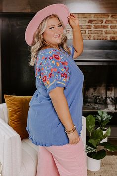 - Take a beachside stroll in this beautiful top! - Unlined material - A wide round neckline - Short sleeves featuring colorful floral embroidery with unfinished frayed cuffs - A relaxed silhouette that ends in a rounded hemline with frayed detail Bohemian Embroidered Hem Top For Beach, Bohemian Blue Top With Tassels, Spring Beach Embroidered Blue Top, Spring Blue Embroidered Top For Beach, Short Sleeve Beach Tops With Frayed Hem, Beach Tops With Frayed Hem And Short Sleeves, Frayed Hem Short Sleeve Tops For Beach, Blue Embroidered Top For Spring Beach Occasion, Bohemian Tops With Embroidered Sleeves For Vacation